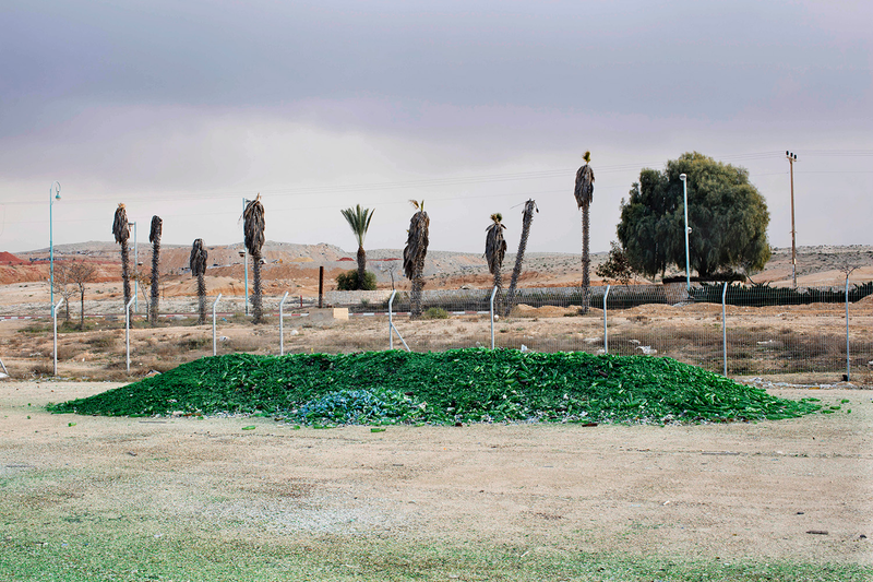Broken glass bottles are piled up to be recycled.